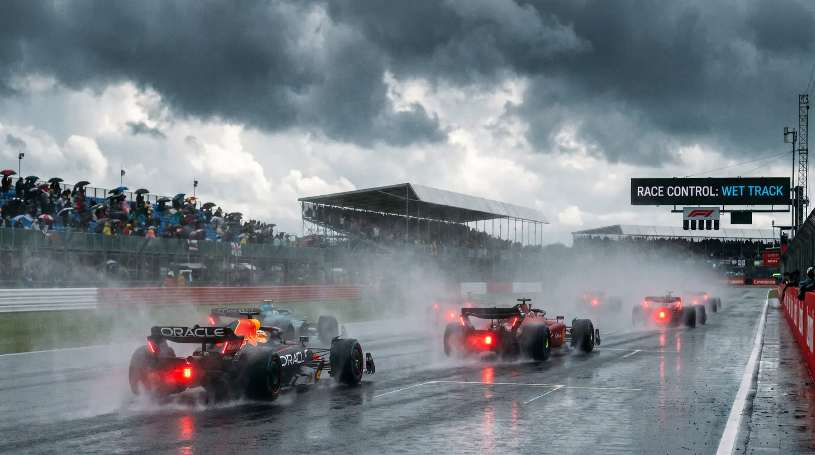 F1 cars racing in wet weather conditions with spray on track surface